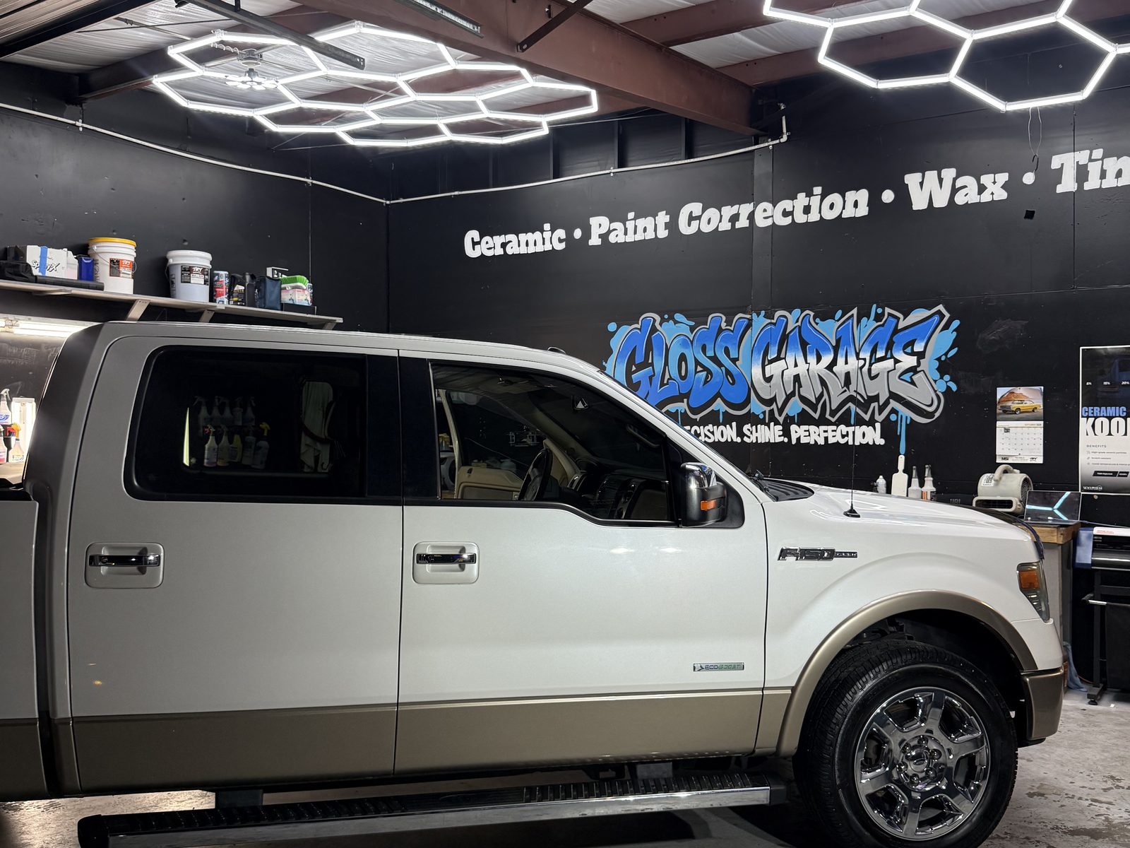 White F-150 side profile under the logo wall