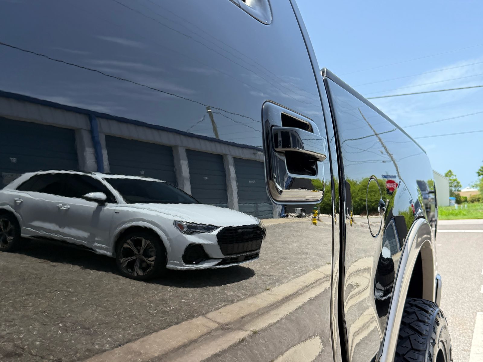White SUV reflected in the corrected black door