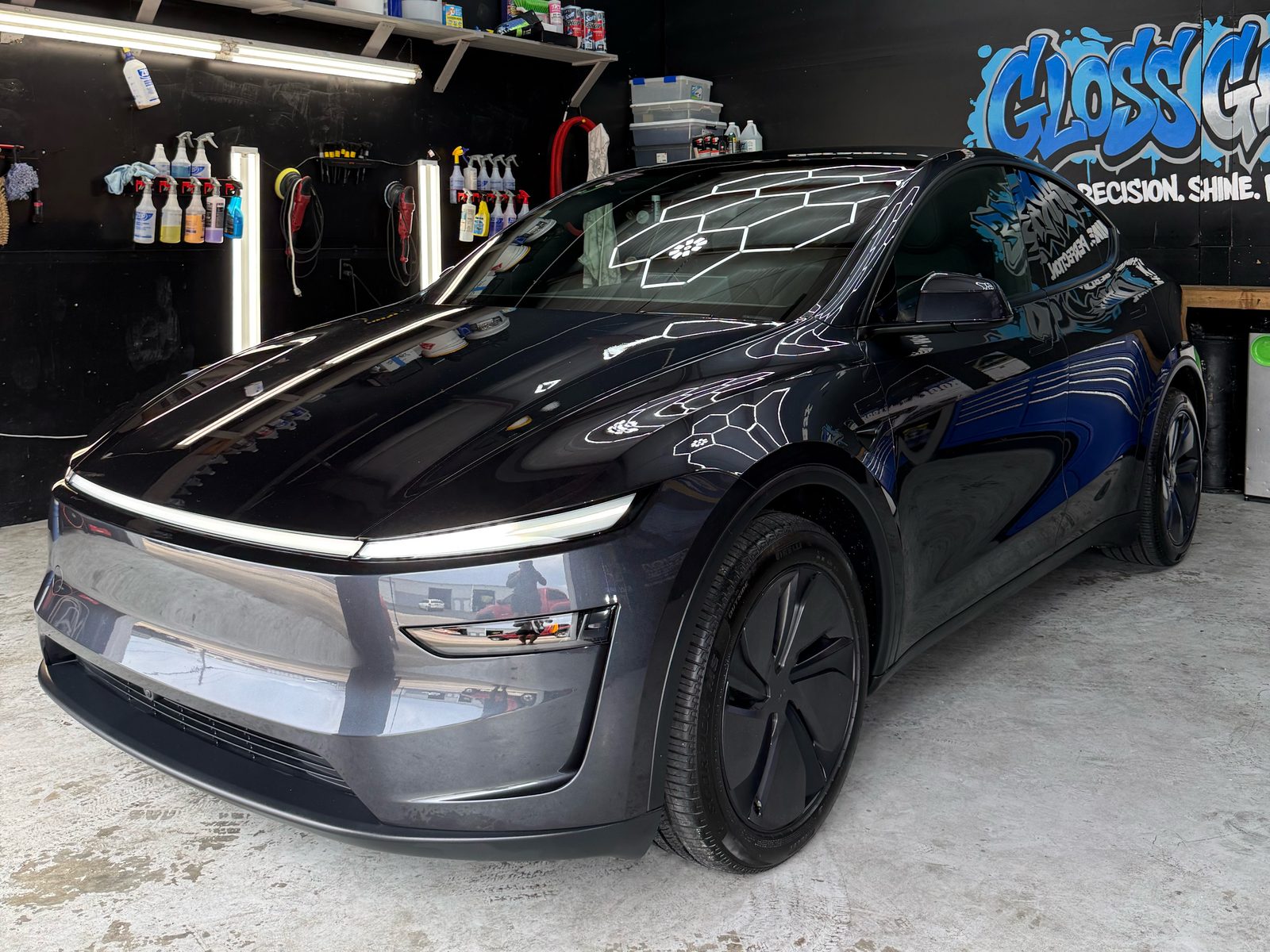Gray Tesla Model Y after ceramic coating, hex shop lights reflecting off the hood and windshield